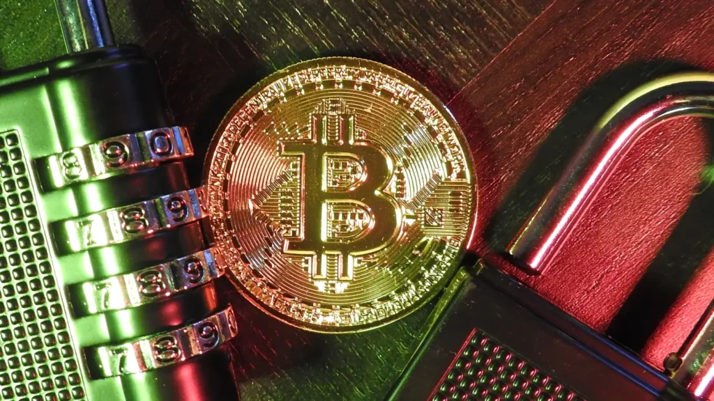 Altın renkli bir Bitcoin sembolü, yanında şifreli bir asma kilit ve başka bir kilit mekanizması ile birlikte, dijital güvenlik ve kripto para kavramlarını temsil eden bir kompozisyon.
